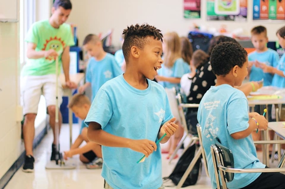 Space camps: A young boy interacts with other students in a classroom.
