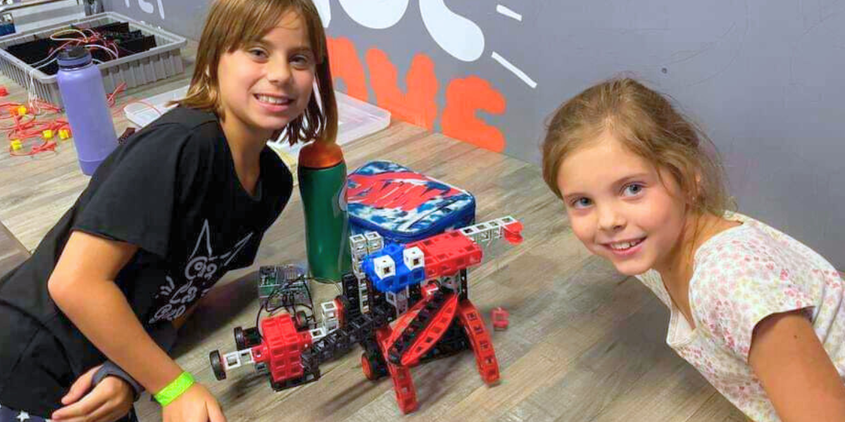 Building the Future: Kids Assembling a Robot Two focused children carefully assemble parts of a robot, using tools and materials to bring their creation to life. This hands-on activity sparks creativity and introduces the basics of robotics engineering.