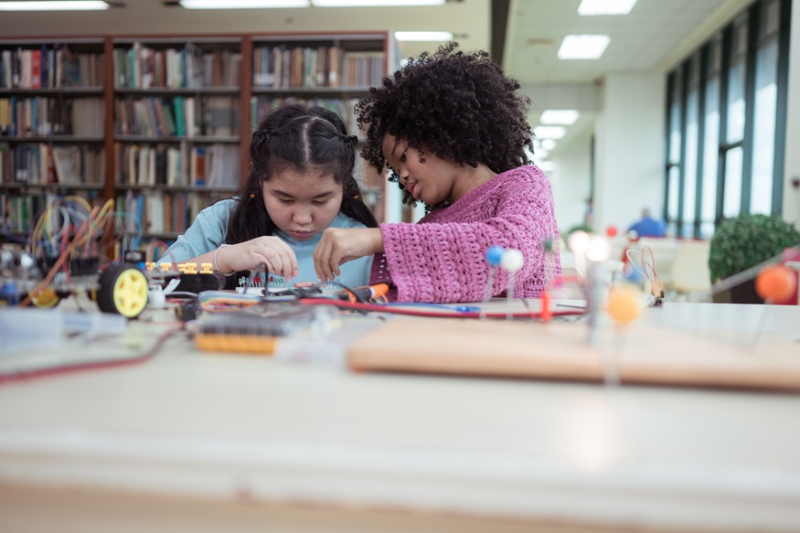 A kid students in a robotics project during a STEM class in the library